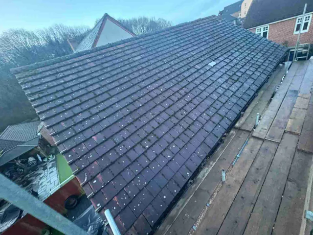 Dark tiled roof viewed along the eaves