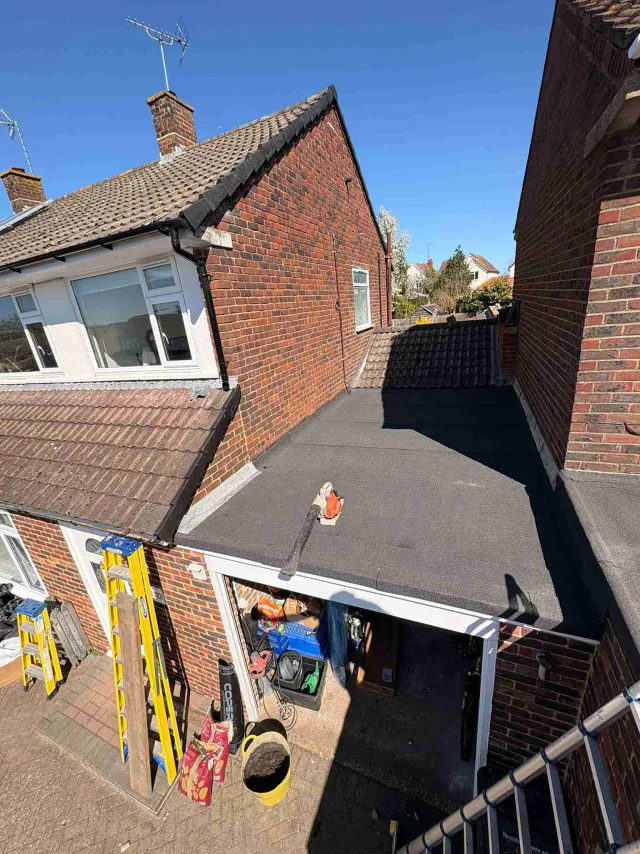 Low-level flat roof beside a brick house