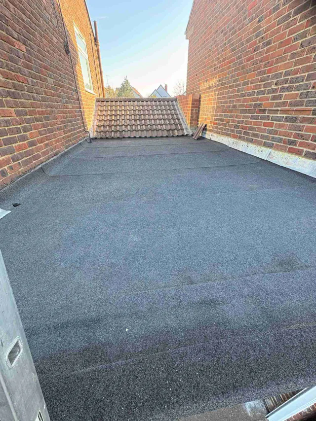 Narrow flat roof between brick walls