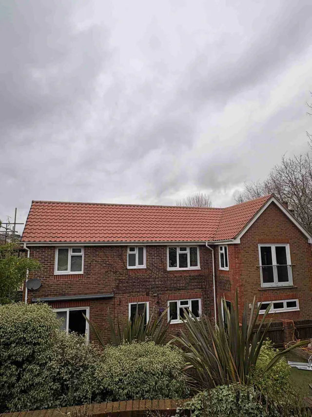 Rear view of a property with a red tiled roof