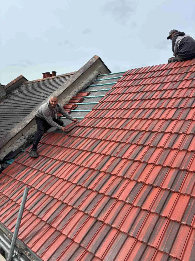 Red roof tiles and ridge detail during work