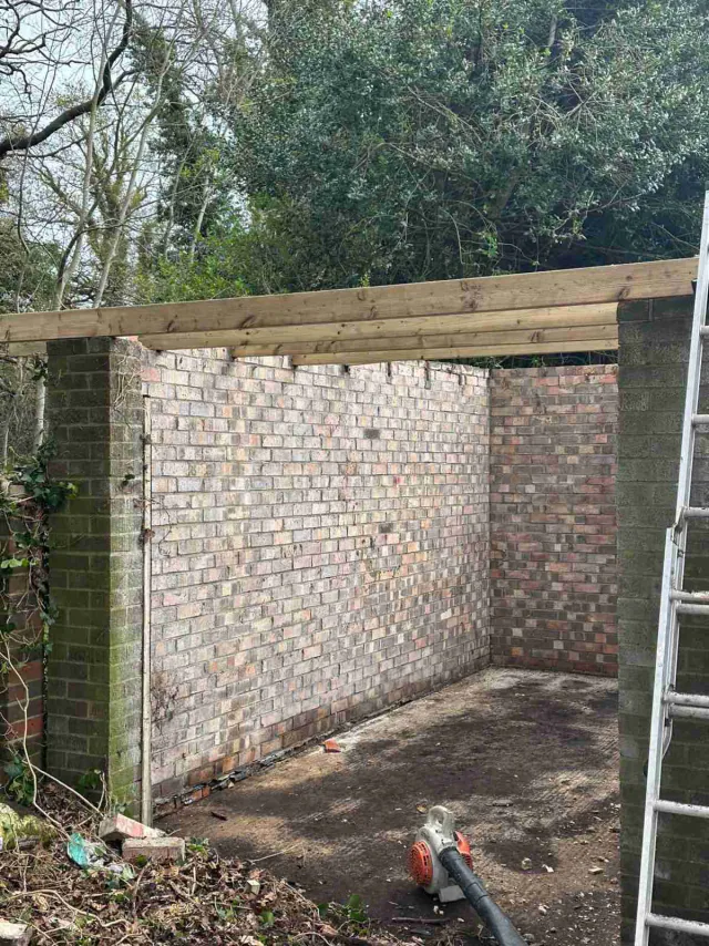 Roof work beside a garden wall