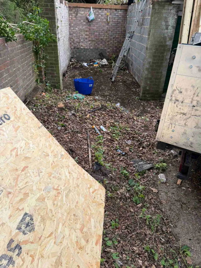 Roof work beside a garden wall