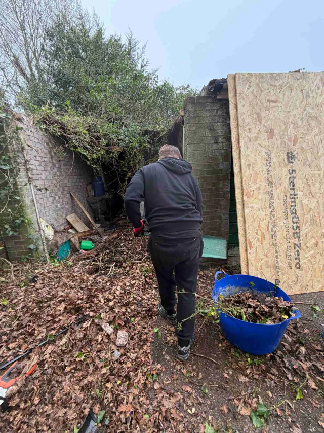 Roof work beside a garden wall