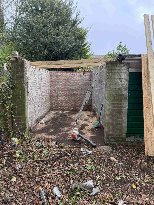 Roof work beside a garden wall