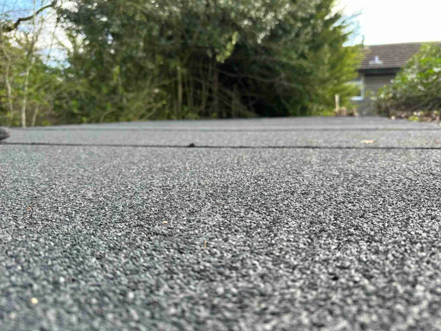 Textured flat roof surface and raised edges